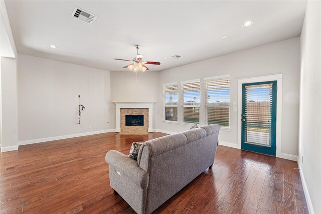 living room featuring a fireplace, dark hardwood / wood-style flooring, and ceiling fan