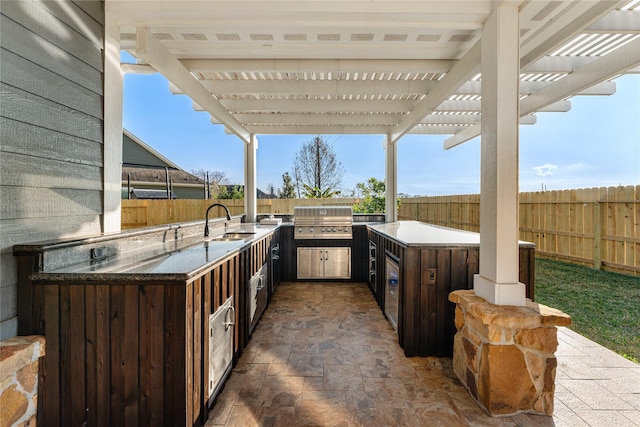 view of patio featuring a pergola, a grill, sink, and an outdoor kitchen