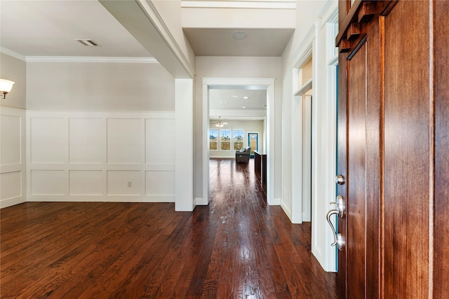 corridor with crown molding and dark wood-type flooring