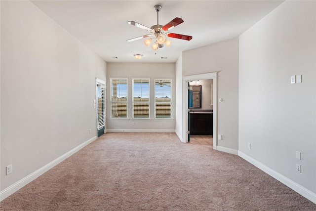 unfurnished bedroom with ceiling fan, light colored carpet, and ensuite bathroom