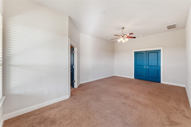 carpeted spare room featuring ceiling fan