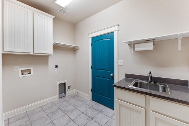 laundry room with hookup for an electric dryer, washer hookup, cabinets, sink, and light tile patterned floors