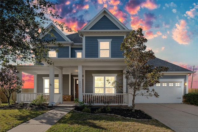 craftsman inspired home with a lawn, covered porch, and a garage