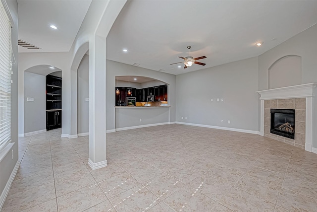 unfurnished living room featuring a fireplace and ceiling fan