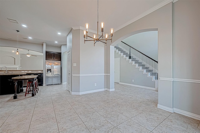 interior space with ceiling fan with notable chandelier, ornamental molding, and light tile patterned flooring