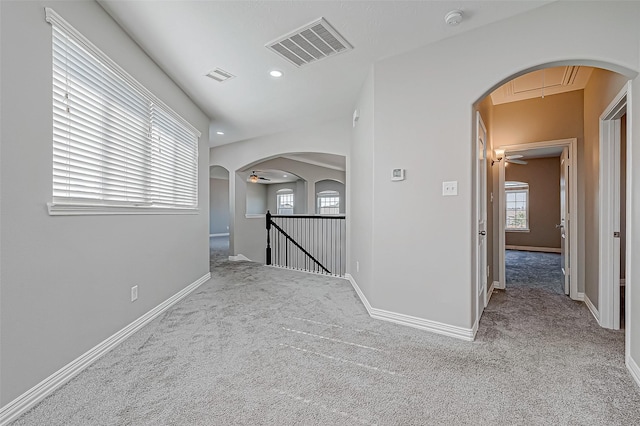 hall featuring light carpet and a healthy amount of sunlight