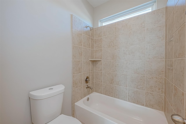 bathroom featuring toilet and tiled shower / bath