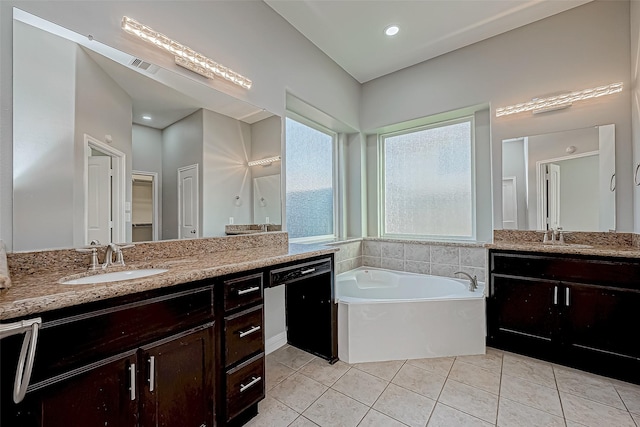 bathroom with a washtub, vanity, and tile patterned floors