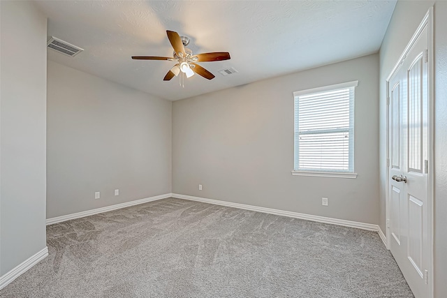 carpeted spare room with ceiling fan