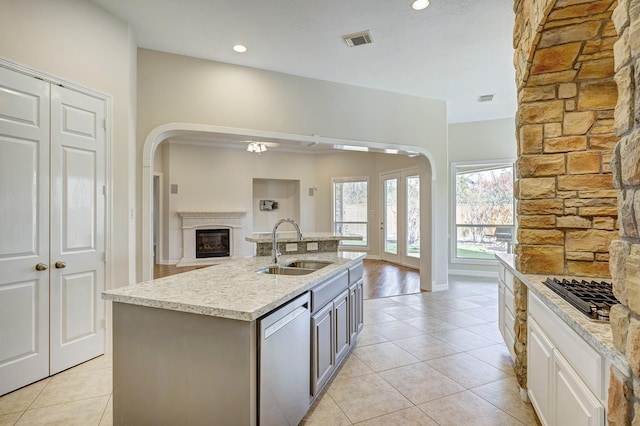 kitchen featuring stainless steel appliances, sink, a center island with sink, white cabinetry, and light tile patterned flooring