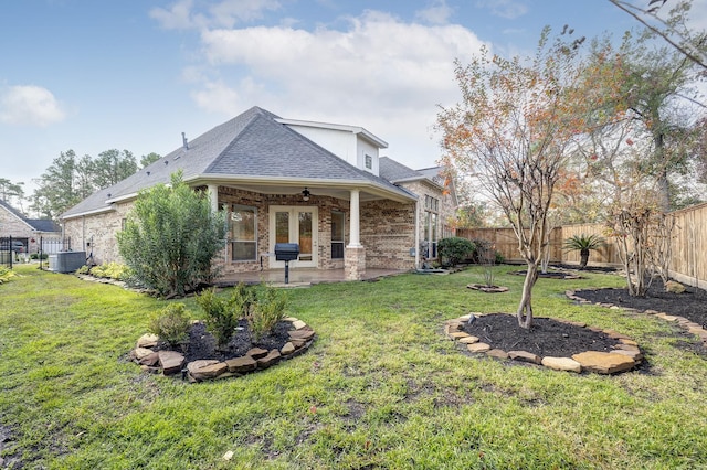 rear view of house featuring central AC unit, ceiling fan, a patio area, and a lawn