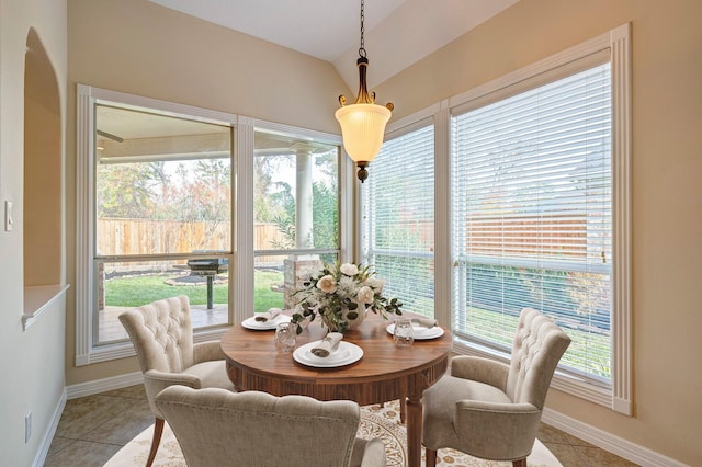 tiled dining space featuring lofted ceiling