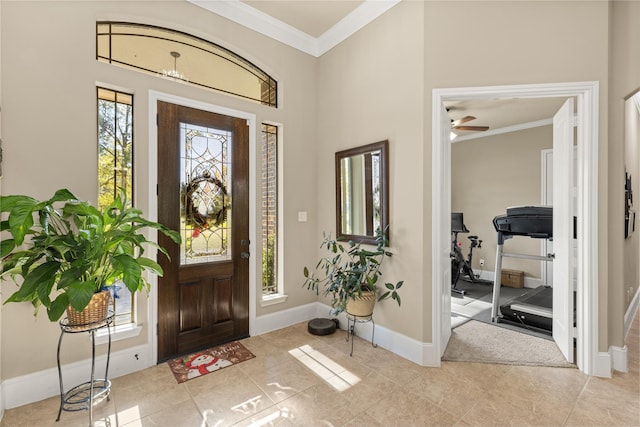 tiled foyer entrance featuring ceiling fan and crown molding