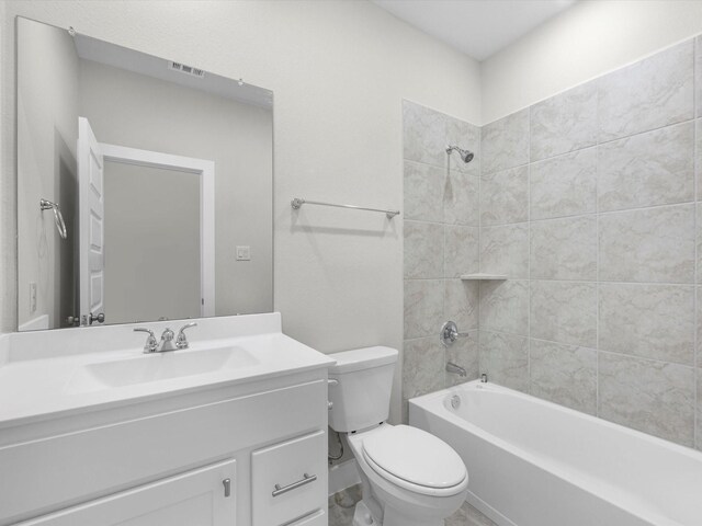 full bathroom featuring tiled shower / bath combo, toilet, and vanity