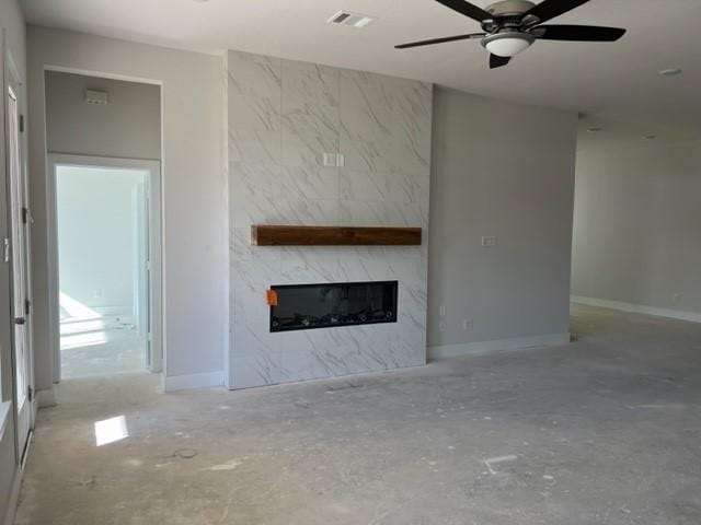 unfurnished living room with a fireplace and ceiling fan