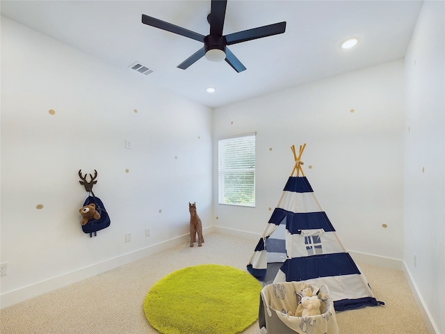 recreation room featuring light colored carpet and ceiling fan