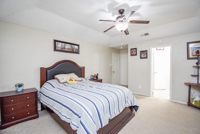 carpeted bedroom featuring a textured ceiling and ceiling fan