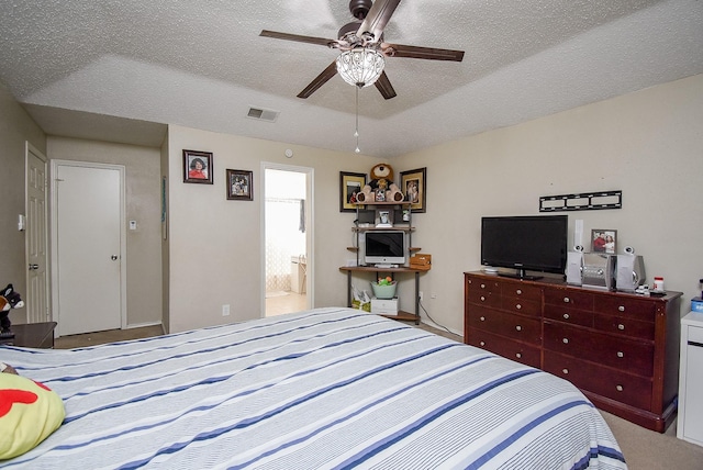 carpeted bedroom featuring ensuite bath, ceiling fan, and a textured ceiling