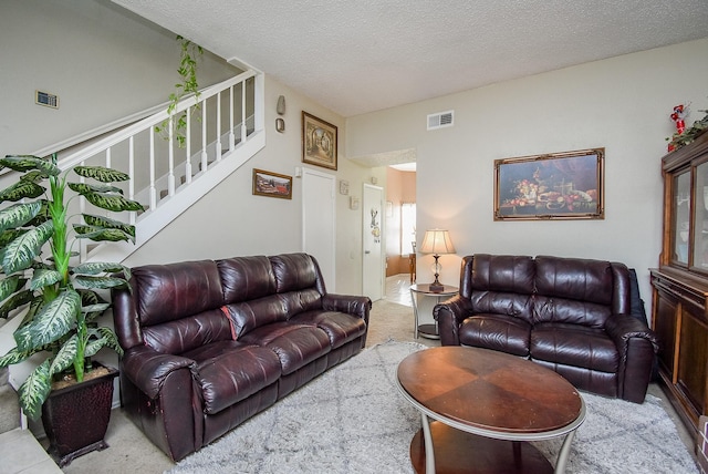 carpeted living room featuring a textured ceiling