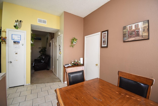 dining room featuring light tile patterned floors and a textured ceiling