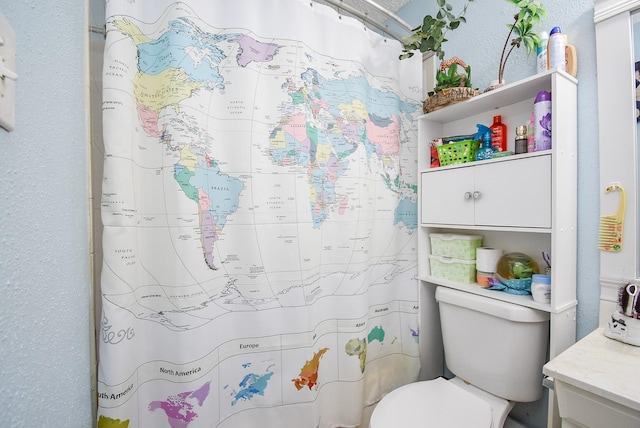 bathroom with a shower with curtain, vanity, and toilet