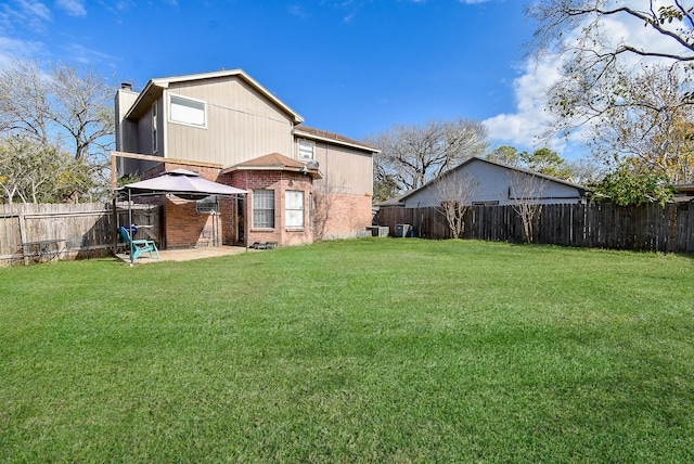 rear view of property with a gazebo, a patio area, and a lawn