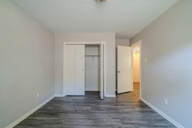 unfurnished bedroom featuring dark wood-type flooring and a closet