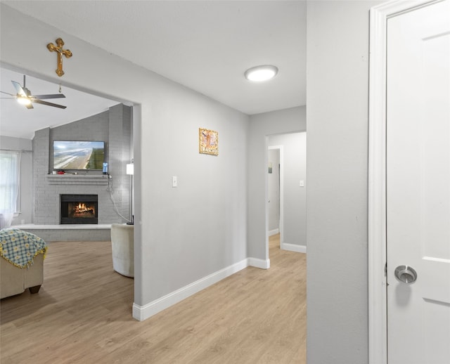 hallway featuring light hardwood / wood-style floors and lofted ceiling