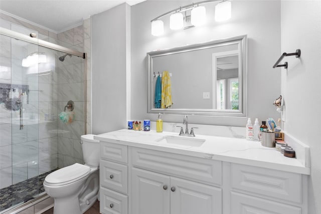 bathroom featuring toilet, an enclosed shower, and vanity