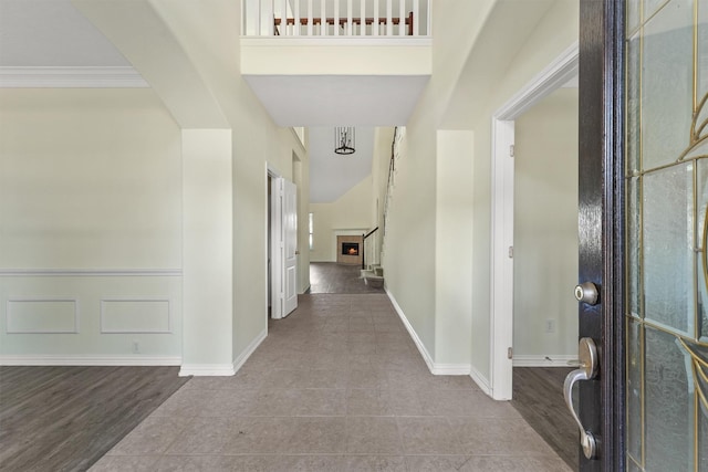 foyer with light wood-type flooring, crown molding, and a high ceiling