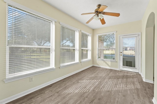 unfurnished sunroom with a wealth of natural light and ceiling fan