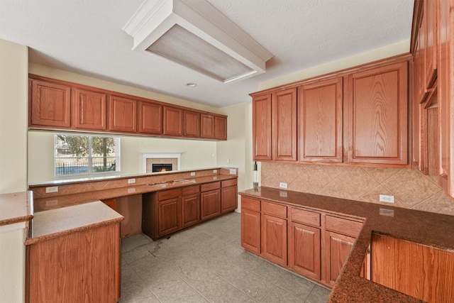 kitchen featuring a textured ceiling, sink, light tile patterned floors, and backsplash