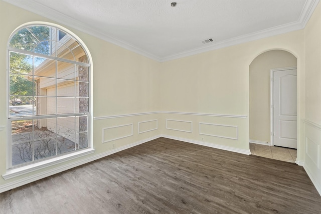 unfurnished room featuring crown molding, dark hardwood / wood-style flooring, and a textured ceiling