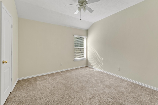 unfurnished room with light colored carpet, vaulted ceiling, and ceiling fan