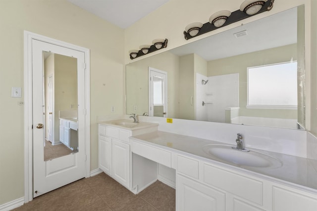 bathroom featuring tile patterned floors, vanity, and a shower