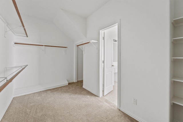 walk in closet featuring light carpet and vaulted ceiling