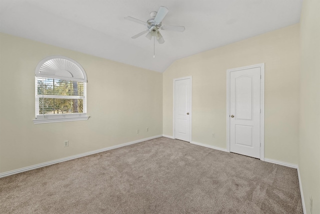 unfurnished bedroom featuring ceiling fan, light colored carpet, and vaulted ceiling