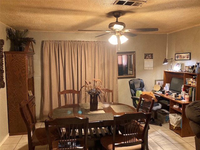 tiled dining room featuring a textured ceiling and ceiling fan