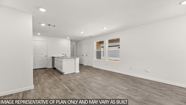 11983 Midas Ln, Willis, TX 77378 - kitchen with wood finished floors, recessed lighting, open floor plan, white cabinets, and light stone counters