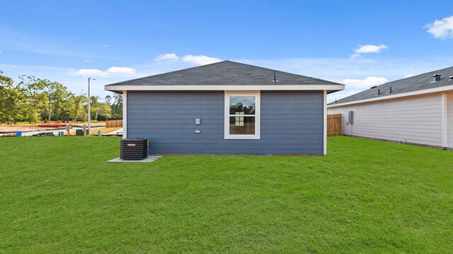 rear view of house featuring a yard and cooling unit