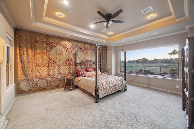 carpeted bedroom featuring a tray ceiling, ceiling fan, and crown molding