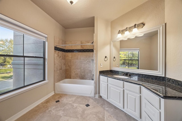 bathroom with vanity, tiled shower / bath combo, and a textured ceiling