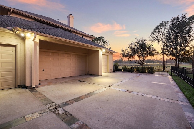 view of garage at dusk