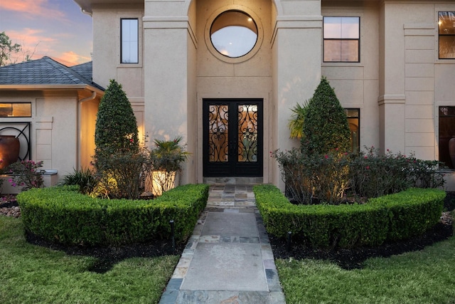 exterior entry at dusk featuring french doors