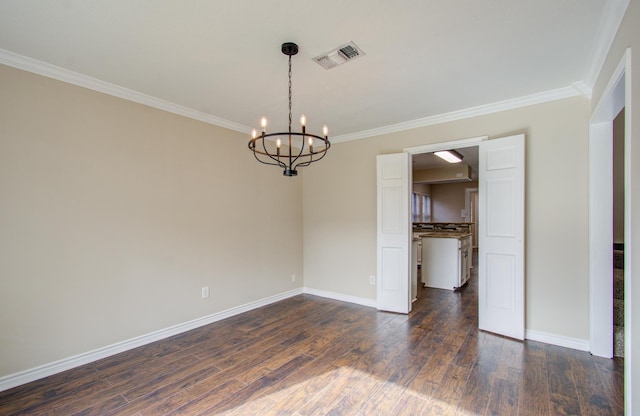 spare room featuring a chandelier, dark hardwood / wood-style flooring, and crown molding