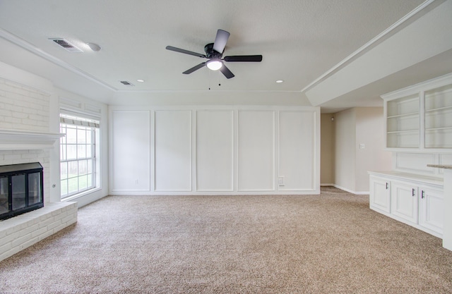 unfurnished living room featuring light colored carpet, a brick fireplace, and ceiling fan