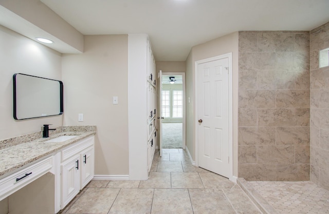 bathroom featuring tile patterned flooring, vanity, ceiling fan, and tiled shower