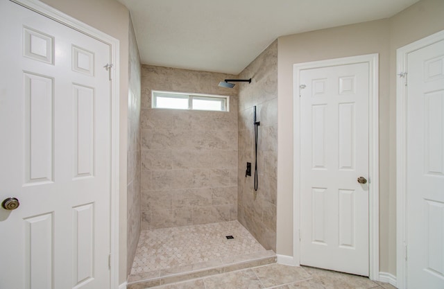 bathroom featuring tile patterned floors and a tile shower