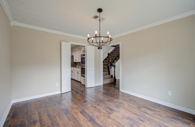 empty room with dark hardwood / wood-style floors, an inviting chandelier, and ornamental molding