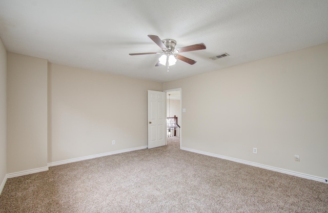 carpeted empty room with ceiling fan and a textured ceiling